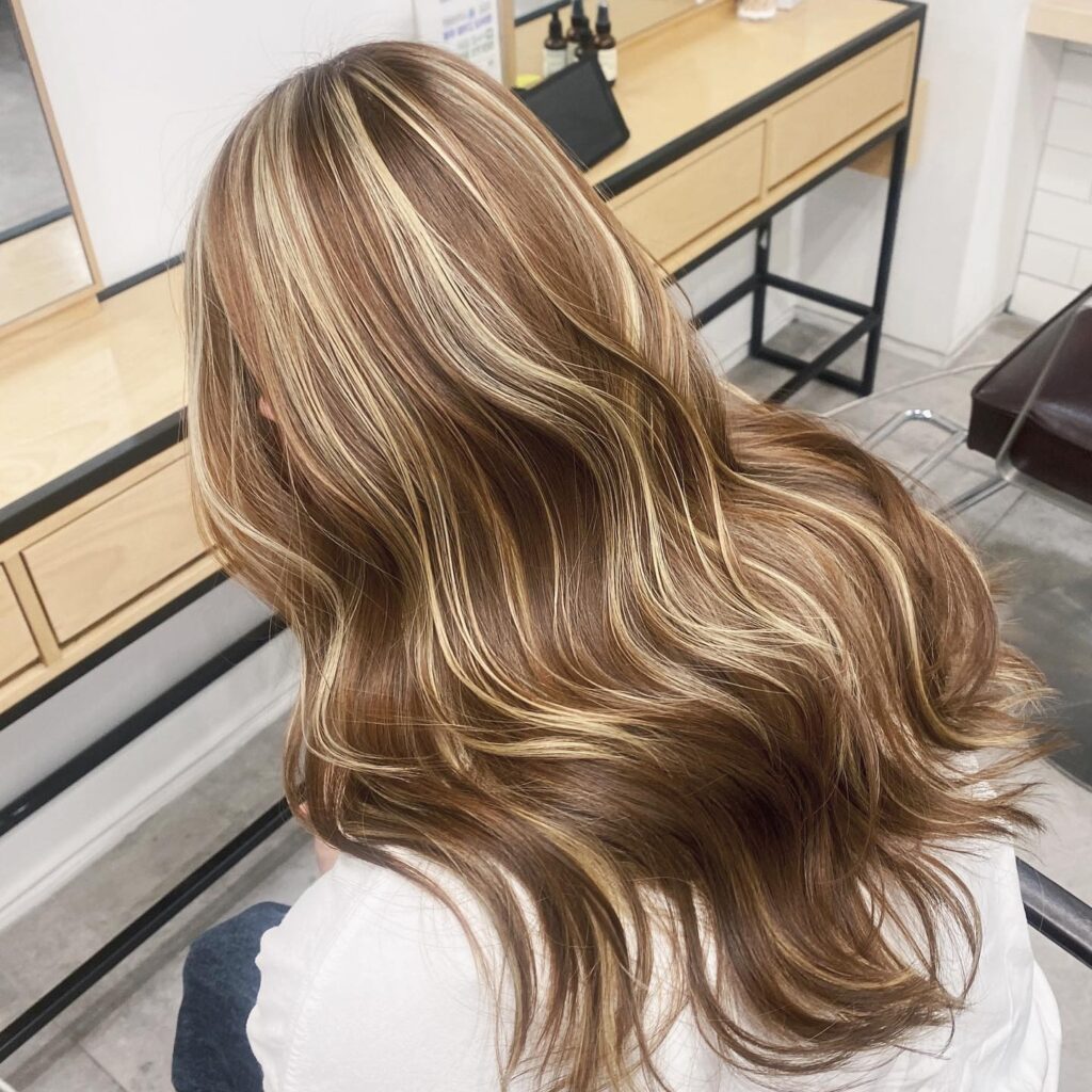 Achieve Ultimate Dimension with Long Hair Balayage at Seoul Hair Salon 1 Seoul Hair Salon’s Long, wavy hair and balayage against light background.
